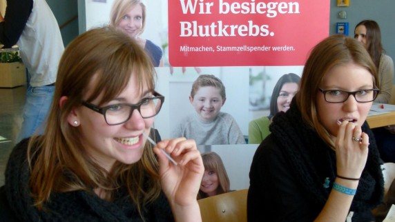 Elisabeth Nefzger (links) und Tanja Lauter sind dabei: Mit einem Wattestäbchen wird eine Speichelprobe für die Deutschen Knochenmarkspenderdatei genommen. 